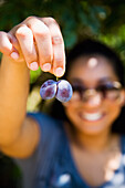 Greece,Halkidiki,Young woman showing plums,Lerissos