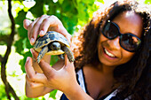 Greece,Halkidiki,Young woman holding juvenile tortoise,Sikia