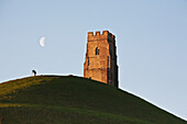 Man Watching Moon With A Telescope Near Tower,Glastonbury,Somerset,England