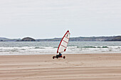 Windjacht auf Sand am Newgale Beach entlang des Pembrokeshire Coast Path bei St. David's, Wales, Großbritannien