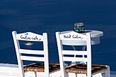 Stühle und ein Tisch auf einer Terrasse mit Blick auf das Wasser vom Hotel Galini und Galini Cafe, Firostefani, Insel Santorin, Griechenland