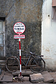 Ein Fahrrad geparkt außerhalb eines Gebäudes mit einem Rikscha-Parkplatz Zeichen, Goa, Indien