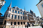 Pedestrians Walking On A Pathway By An Building With Spires,Luxembourg