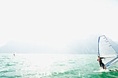 Eine Frau beim Windsurfen auf dem Gardasee, Riva Del Garda, Trento, Norditalien