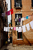 Wäsche auf Wäscheleinen über einer Straße im Giardini-Gebiet, Venedig, Italien