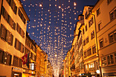 Kleine weiße Lichter aufgereiht über einer Straße zur Weihnachtszeit, Stadt Zürich, Zürich, Schweiz