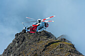 Rettungshubschrauber der Küstenwache über dem Bergrücken der Black Cuillin, Isle Of Skye, Schottland
