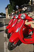 Drei rote Vespa-Roller zu vermieten, geparkt in Radda In Chianti, Toskana, Italien