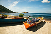 Nahaufnahme von traditionellen Einbaum-Fischerbooten, die entlang der Strandpromenade im kleinen Fischerdorf Soufriere auf der Insel Dominica gestrandet sind,Soufriere,Dominica,Karibik