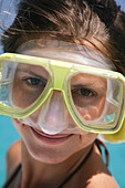 Close-up portrait of a young woman wearing snorkeling gear,posing and smiling at the camera at Stingray City (a popular offshore sandbar where stingrays have become habituated to humans allowing them to swim safely alongside the animals),Grand Cayman,Cayman Islands,Caribbean