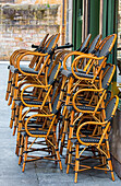 Black and white,bamboo chairs stacked in rows on a sidewalk outside of a building in the City of Bilbao the Capital of Basque Country,Bilbao,Biscay,Spain