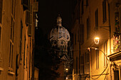 Large dome of Marseille Cathedral at night viewed between buildings illuminated by a light,Marseille,France