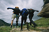 Teilnehmer der Three Peaks Challenge laufen einen Steinweg entlang, Ben Nevis, Schottland