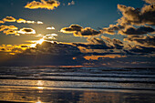 Atemberaubend schöner Sonnenuntergang, der sich in der Brandung an der Küste Washingtons spiegelt, Ilwaco, Washington, Vereinigte Staaten von Amerika