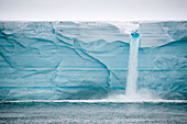Schmelzwasser ergießt sich über eine Eisklippe von der Oberfläche der Nordaustlandet-Eiskappe, Svalbard, Norwegen