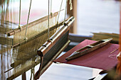 Gespannte Stränge aus feinem Garn in traditionellen Webstühlen in Ock Pop Tock, dem Zentrum für lebendiges Kunsthandwerk, Luang Prabang, Laos