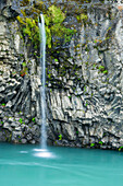 Small waterfall cascades past basalt formations,near Gullfoss waterfall,Iceland