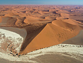 Luftaufnahme von windverwehten Sanddünen, die sich weit in die Ferne erstrecken, im Namib-Naukluft Park, Sossusvlei, Namibia