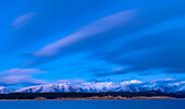 Frischer Schnee bedeckt die Rhoboro Hills bei Sonnenaufgang mit dem ruhigen Lake Pukaki im Vordergrund, Twizel, Südinsel, Neuseeland