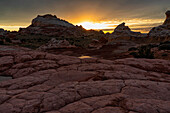 Sonnenuntergang über dem wundersamen Gebiet White Pocket, das in Arizona liegt. Es ist eine fremdartige Landschaft mit erstaunlichen Linien, Konturen und Formen. Hier erzeugt die untergehende Sonne wunderschöne Farben am Himmel über dem Gebiet, Arizona, Vereinigte Staaten von Amerika