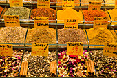 Warm colored spices for sale,heaped in plastic bins on display in a shop in the Spice Bazaar in the Fatih District,Istanbul,Turkey
