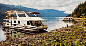 Eine Familie genießt ihren Urlaub auf einem Hausboot, das am Ufer des Shuswap Lake, Shuswap Lake, British Columbia, Kanada, geparkt ist