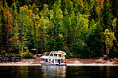 A vacation houseboat parked on the shoreline of Shuswap Lake in autumn,Shuswap Lake,British Columbia,Canada