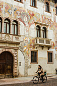 Quetta Alberti Colico Palace with 16th century frescoed facade and cyclist,Trento,Trentino,Italy