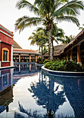 Palme spiegelt sich in einem Pool in einem tropischen Resort, Mexiko