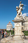 Baptistry and Cathedral of Pisa with sculpture of angels in the foreground,Pisa,Tuscany,Italy