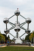 Großes Kunstwerk aus Edelstahl in Form eines Atoms mit blauem Himmel und Sonnenaufgang,Brüssel,Belgien