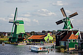 Historical wooden windmills along the banks of the River Zaan with blue sky and clouds,Zaandam,Netherlands