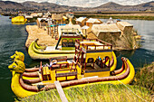 Colourful boats are tied to a floating reed island on Lake Titicaca,Puno,Puno,Peru
