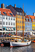 Boote und Menschen entlang des bunten Hafenviertels Nyhavn, Kopenhagen, Dänemark