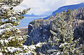 Vista House on Crown Point Promontory in the Columbia River Gorge in winter,with snow-covered evergreen trees in the foreground,Corbett,Oregon,United States of America