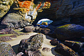Ein Blick auf den Pazifischen Ozean und die Küste durch einen natürlichen Bogen und Felsen an der zerklüfteten Küste von Oregon, Newport, Oregon, Vereinigte Staaten von Amerika