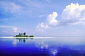 Eine kleine Insel mit weißem Sand und Palmen im Indischen Ozean mit Wolken, die sich im ruhigen blauen Wasser spiegeln, Malediven