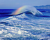 Plätschernde Welle mit Farben im Nebel am Ufer von Cape Kiwanda entlang der Küste von Oregon in Cape Kiwanda State Natural Area, Oregon, Vereinigte Staaten von Amerika