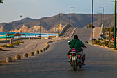 Mann fährt Motorrad an der Küste Ecuadors, Puerto Lopez, Manabi, Ecuador