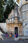 Drei Frauen sitzen in einem Hindu-Tempel am Ufer des Pichola-Sees, Udaipur, Rajasthan, Indien