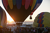 At sunrise,several hot air balloons take off as others inflate near a crowd at the Prosser Balloon Rally.,Prosser,Washington