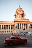 Ein amerikanischer Oldtimer fährt am El Capitolio Gebäude in der Innenstadt von Havanna vorbei,Havanna,Kuba
