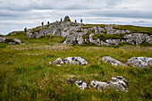 Hikers reach the summit of Dun I,a small hill overlooking the Benedictine Abbey on Iona,Scotland,Iona,Isle of Iona,Scotland