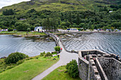 Besucher überqueren die Dammbrücke zum Eilean Donan Castle in der Nähe von Kyle of Lochalsh, Schottland, Kyle of Lochalsh, Schottland