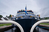 Reisende versammeln sich am Bug eines Ausflugsbootes, um die Einfahrt in eine Schleuse am Caledonian Canal bei Fort Augustus, Schottland, Fort Augustus, Schottland, zu beobachten.