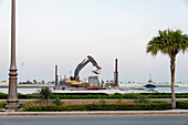 Ein Bagger entert einen Lastkahn an der Küste des Persischen Golfs in Abu Dhabi, Vereinigte Arabische Emirate, Abu Dhabi, Vereinigte Arabische Emirate