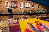 Display of artwork of Blues musicians along a bar with bottles of alcohol in a Blues Club,Chicago,Illinois,United States of America