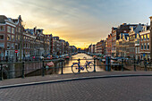 Bicycle parked on canal bridge at sunset on Spiegelgracht (Brug 69),Amsterdam,North Holland,Netherlands
