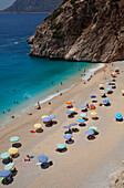 Touristen und Sonnenschirme am Strand von Kaputas, in der Nähe von Kas, Türkei, Türkei