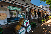Boutiquen und ein Weinladen mit dekorativen Fässern an der Weinstraße in Südafrika, Stellenbosch, Südafrika